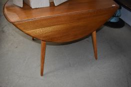 An Ercol style drop leaf kitchen table having splay legs