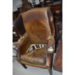 A vintage leather wing armchair
