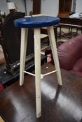 A lab style stool having wood frame with metal supports to triple splay legs