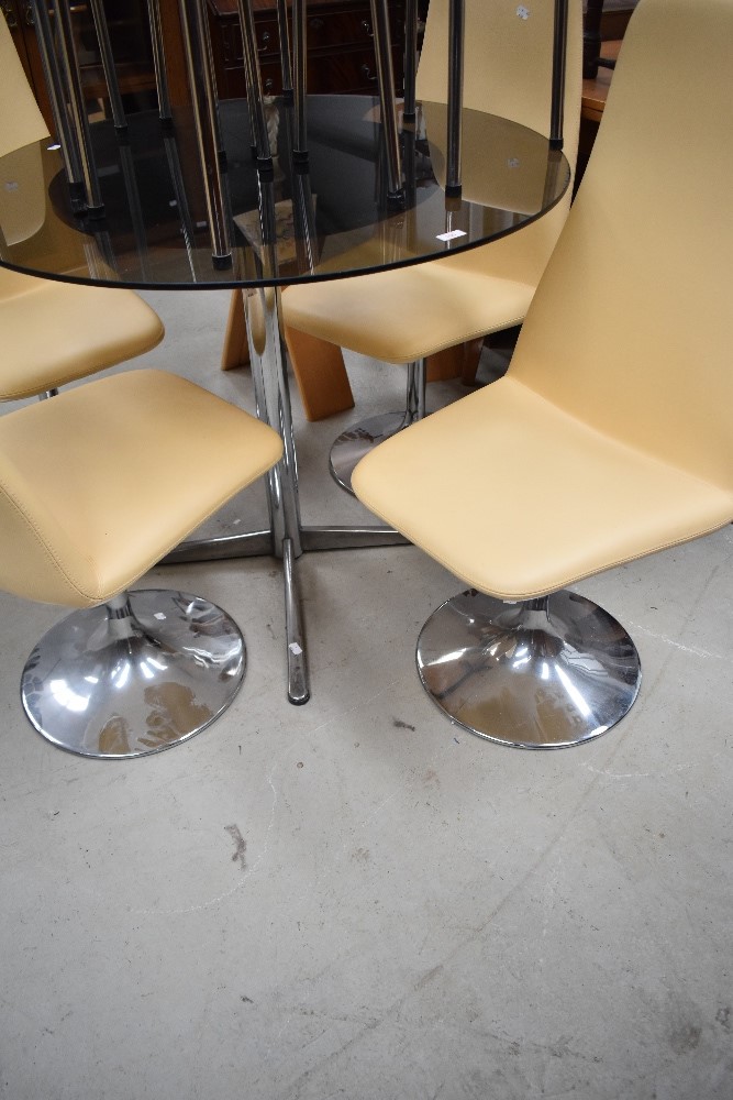 A vintage or retro smoked glass dining table and set of four stylised chairs
