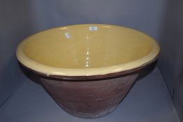 A large antique farm house butter or cream bowl, terracotta body with cream glaze inner, measure
