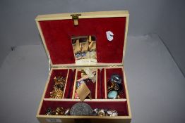 A jewellery case containing a selection of costume jewellery clip earrings, brooches etc