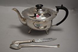 A silver plated tea pot having hard wood handle, frilled rim and paw feet, and three pieces of