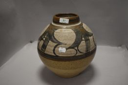 A vintage studio pottery vase by Donald Glanville having a naturalistic glaze approx 26cm tall