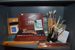 A collection of art materials including brushes,pastel pencils and paper etc.