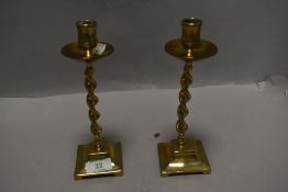 A pair of Victorian brass candlestick holders having barely twist columns.