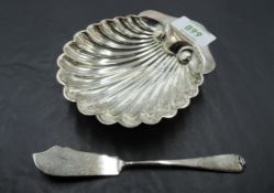 A cased silver scallop shell form butter dish and knife, marks for London 1910, maker Josiah