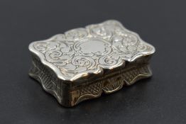 A small Victorian silver vinaigrette of shaped form having pierced gilt grill and interior, engraved