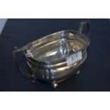 A 1920's silver two-handled sugar bowl, with gadrooned rim, angular handles and moulded body