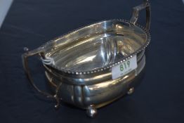 A 1920's silver two-handled sugar bowl, with gadrooned rim, angular handles and moulded body