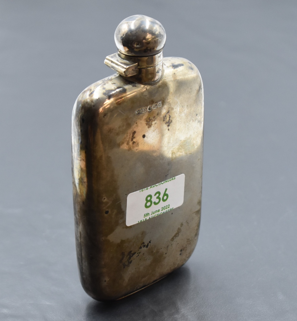 An Edwardian silver hip flask, of rounded rectangular form, curved for the gentleman's pocket, marks