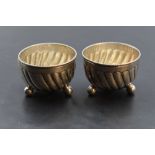 A pair of Victorian silver salts, of circular spirally fluted form with beaded rim, raised on