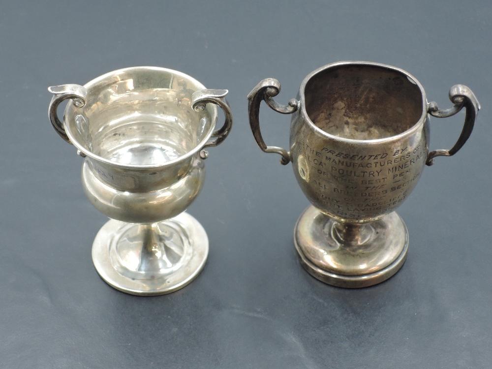 Two small early 20th century two-handled silver trophies, each with engraved inscriptions, marks for