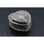 An Edwardian silver lidded cut glass heart shaped dressing table jar, the silver lid with crimped