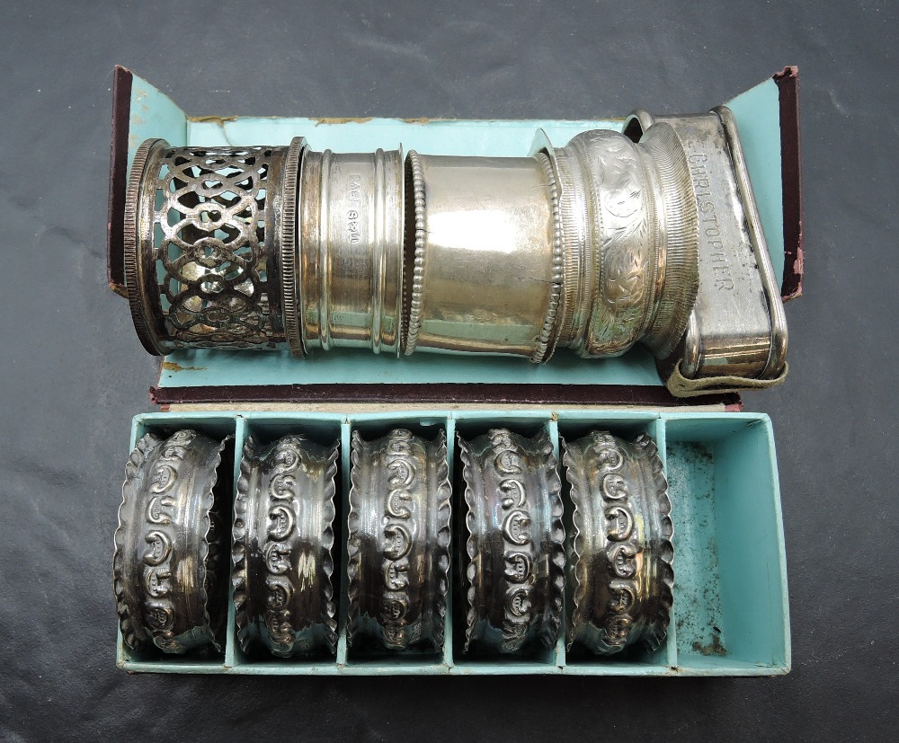 A group of five silver napkin rings, embossed with scrolls and ruffled edge detail, marks for