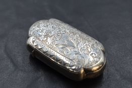 A Victorian silver vesta case, of lobed rectangular form, engraved with folaite scrolls, the
