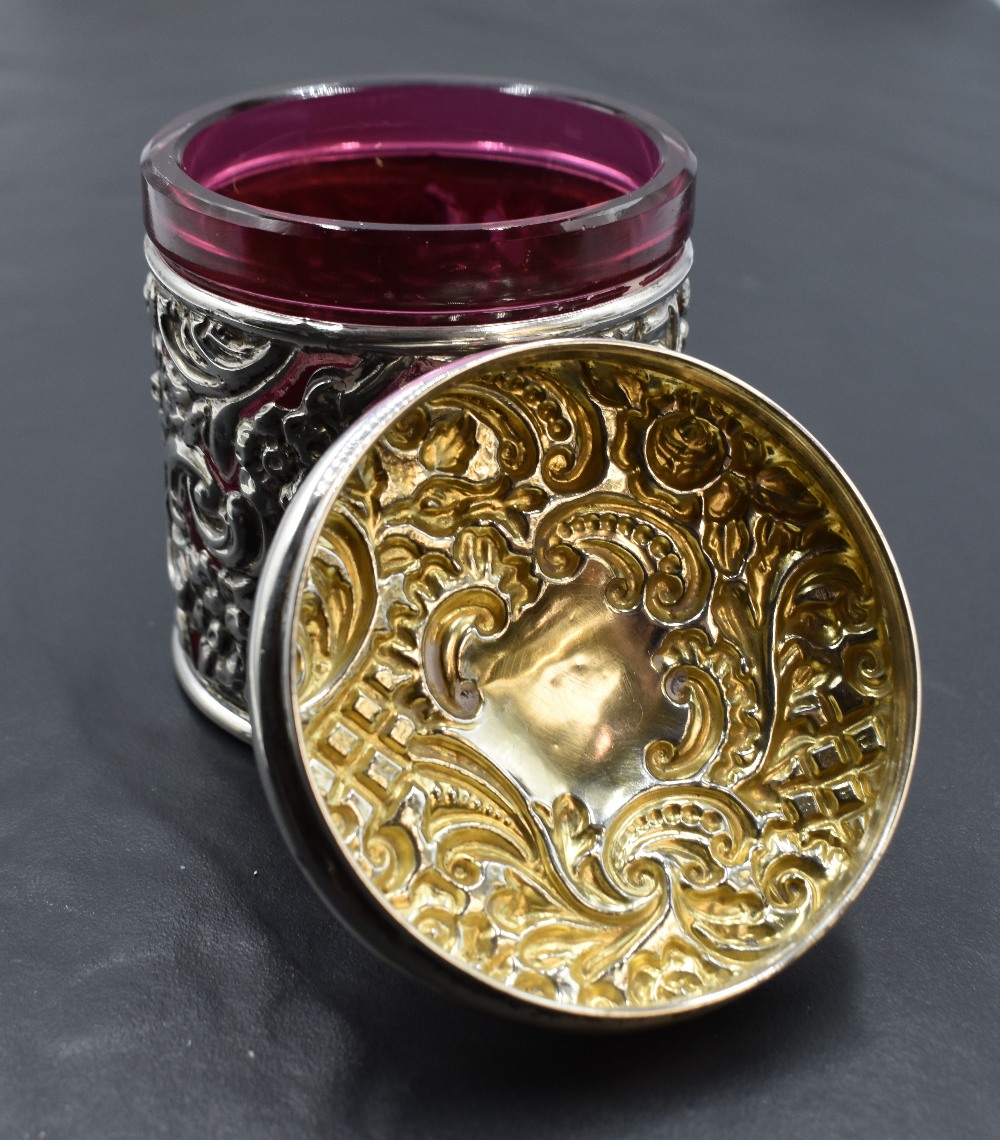 A Victorian silver mounted cranberry glass jar, of circular form, the foliate scroll moulded pull- - Image 2 of 2