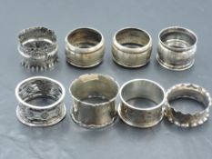 A group of eight mixed silver napkin rings, mainly early 20th century, various designs, dates and