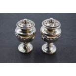 A pair of 19th century silver pepperettes, of urn-form with pierced finial topped pull-off covers