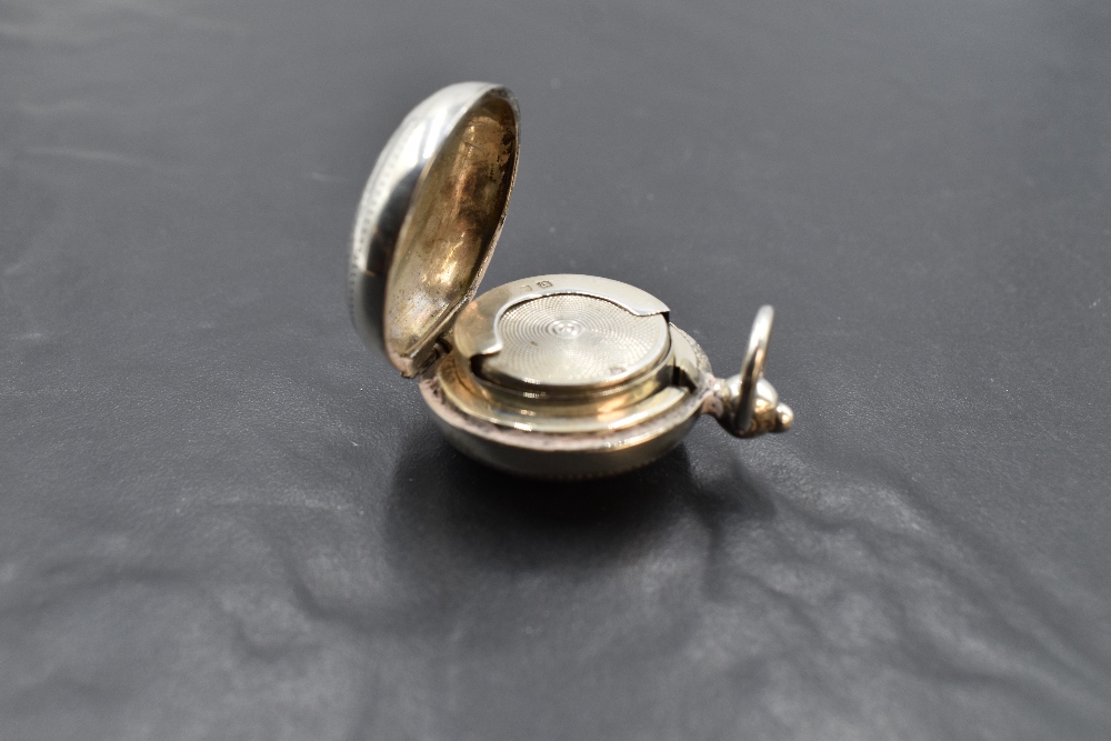 A late Victorian silver sovereign holder, of hinged circular form engraved with foliate detail, - Image 2 of 2