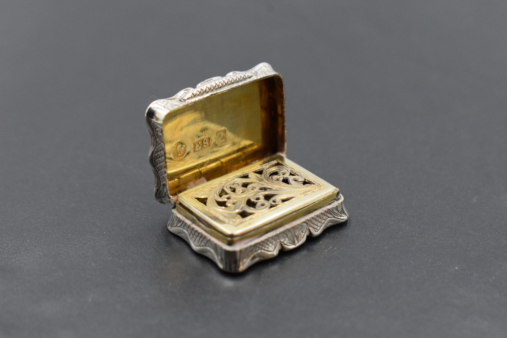 A small Victorian silver vinaigrette of shaped form having pierced gilt grill and interior, engraved - Image 2 of 3