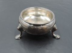 An 18th century silver salt, of circular form with cabriole type legs and hoof feet, engraved