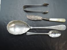 An Edwardian silver salad serving spoon, with foliate engraving to the shaped bowl and stem, marks