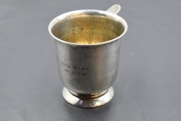 A hallmarked silver cup, of flared cylindrical form with applied ring handle and circular foot,