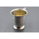 A hallmarked silver cup, of flared cylindrical form with applied ring handle and circular foot,