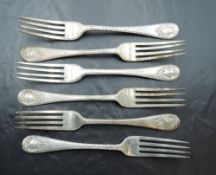 A group of six Edwardian silver dessert forks, each with fluted edge detail and scrolled cartouche