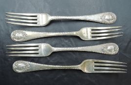A group of four Edwardian silver table forks, each with fluted edge detail and scrolled cartouche to