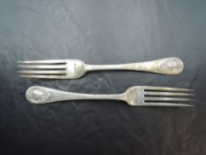 A pair of Edwardian silver table forks, with fluted edge detail and scrolled cartouches, engraved