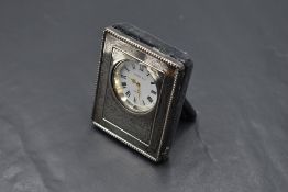 A small modern silver mounted desk clock, with moulded bead decoration and engraved initials,
