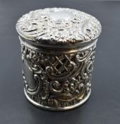 A Victorian silver mounted cranberry glass jar, of circular form, the foliate scroll moulded pull-
