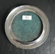 An Edwardian silver photograph frame of circular form having green leather covered easel back,