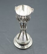 A continental white metal trophy, of half-egg form with cockerel mask ornaments, supported by