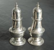 A pair of silver pepperettes of waisted baluster form having push on lids, Chester 1919, Stokes &