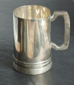 A Victorian silver tankard of plain form having moulded handle and reided decoration to base,