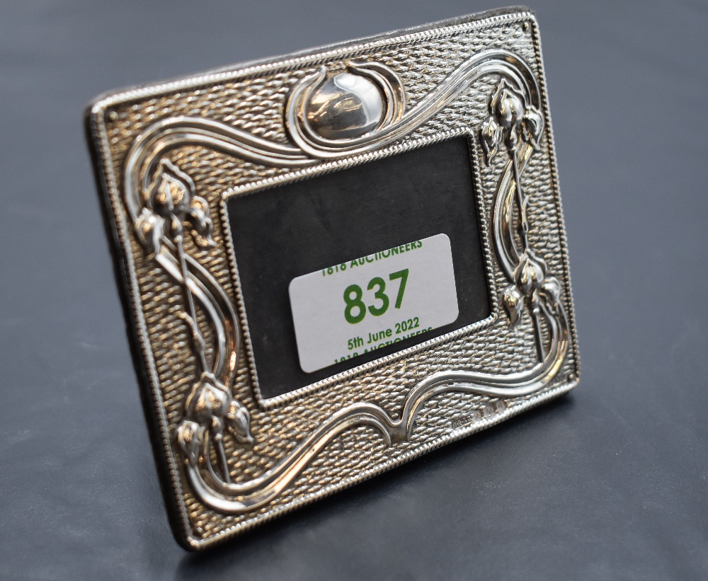 A small Edwardian silver photograph frame having Art Nouveau iris decoration with plain cartouche