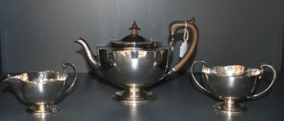 A 1920's three piece silver teaset, of circular form with shaped rims, marks for Sheffield 1922,