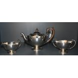 A 1920's three piece silver teaset, of circular form with shaped rims, marks for Sheffield 1922,