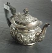 A late Victorian silver teapot, of moulded and rounded rectangular form, the domed cover with