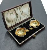 A cased pair of late Victorian silver salts, of scallop shell form with gilt interiors and three
