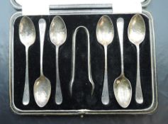 A cased set of six silver teaspoons with matching sugar nips, all having hammered finish,