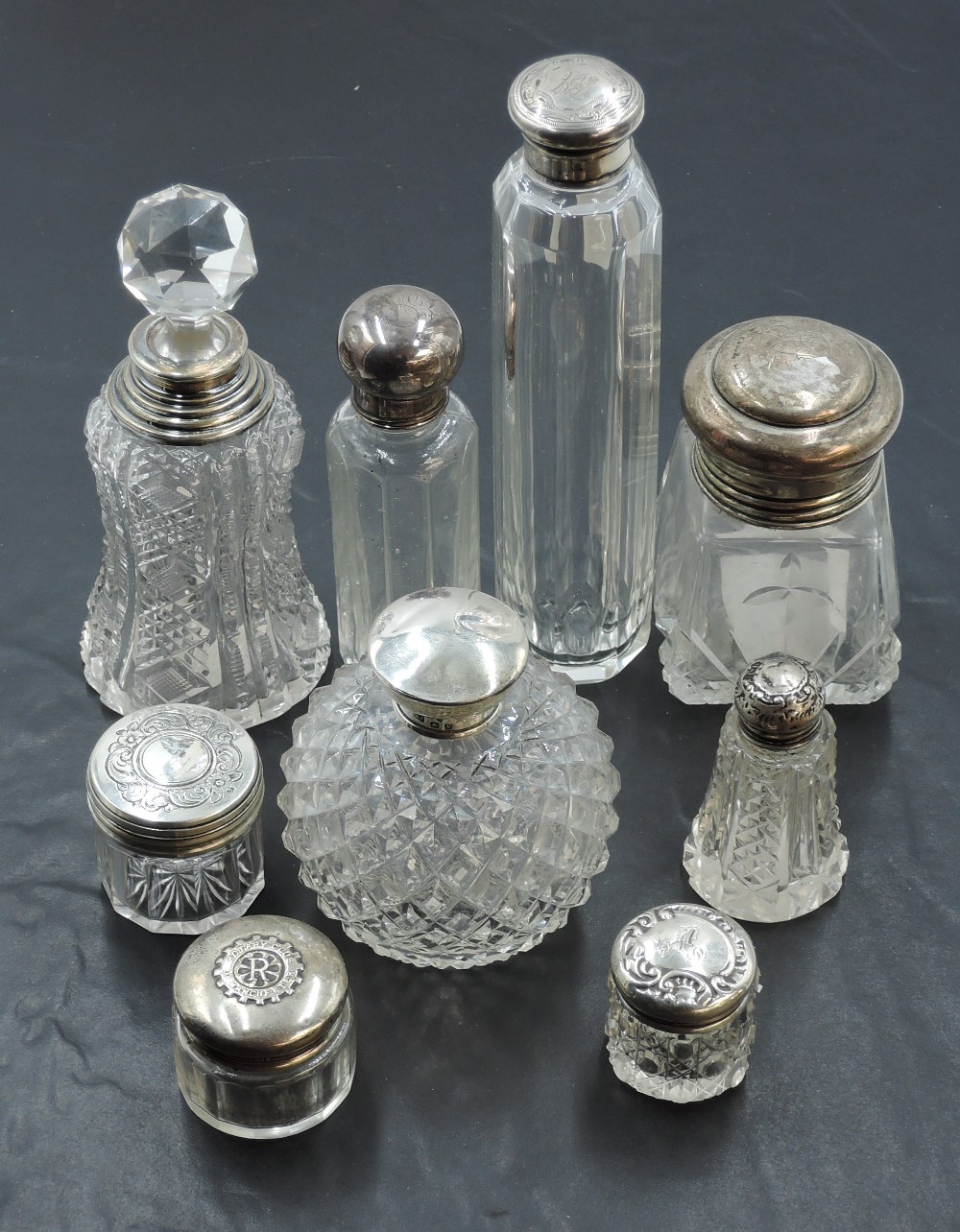 A selection of silver topped glass dressing table jars and scent bottles, to include a small 'Rotary