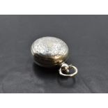 A late Victorian silver sovereign holder, of hinged circular form engraved with foliate detail,