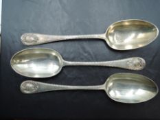 A group of three Edwardian silver table spoons, with fluted edge detail and scrolled cartouches,