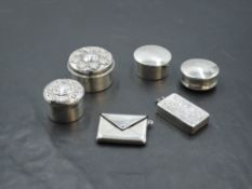 Four HM silver patch boxes, an HM silver stamp holder in form of an envelope and a similar white