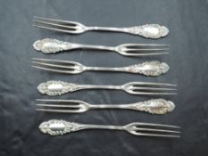 A set of six Sterling silver pickle forks, with scroll-moulded terminals, marked 'Sterling' 11.
