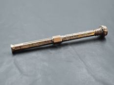 A 9ct gold propelling pencil, with sliding adjustment, having engraved decoration and inset purple